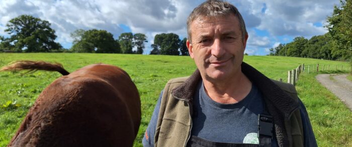 New Forest CDA chairman Andrew Parry-Norton in a field next to a cow